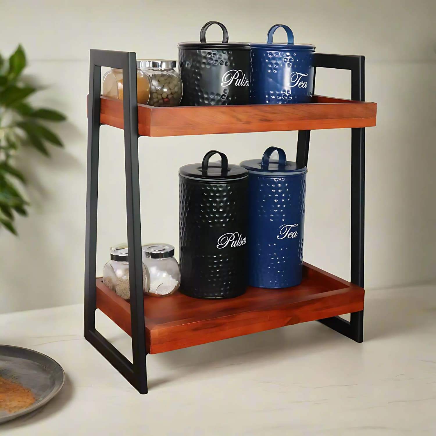 Loosebucket Linea Premium Wooden Kitchen Organizer featuring two-tier walnut-finished acacia wood shelves with black metal frame, displaying decorative blue and black storage canisters for pulses and tea. Modern industrial design with rustic appeal.