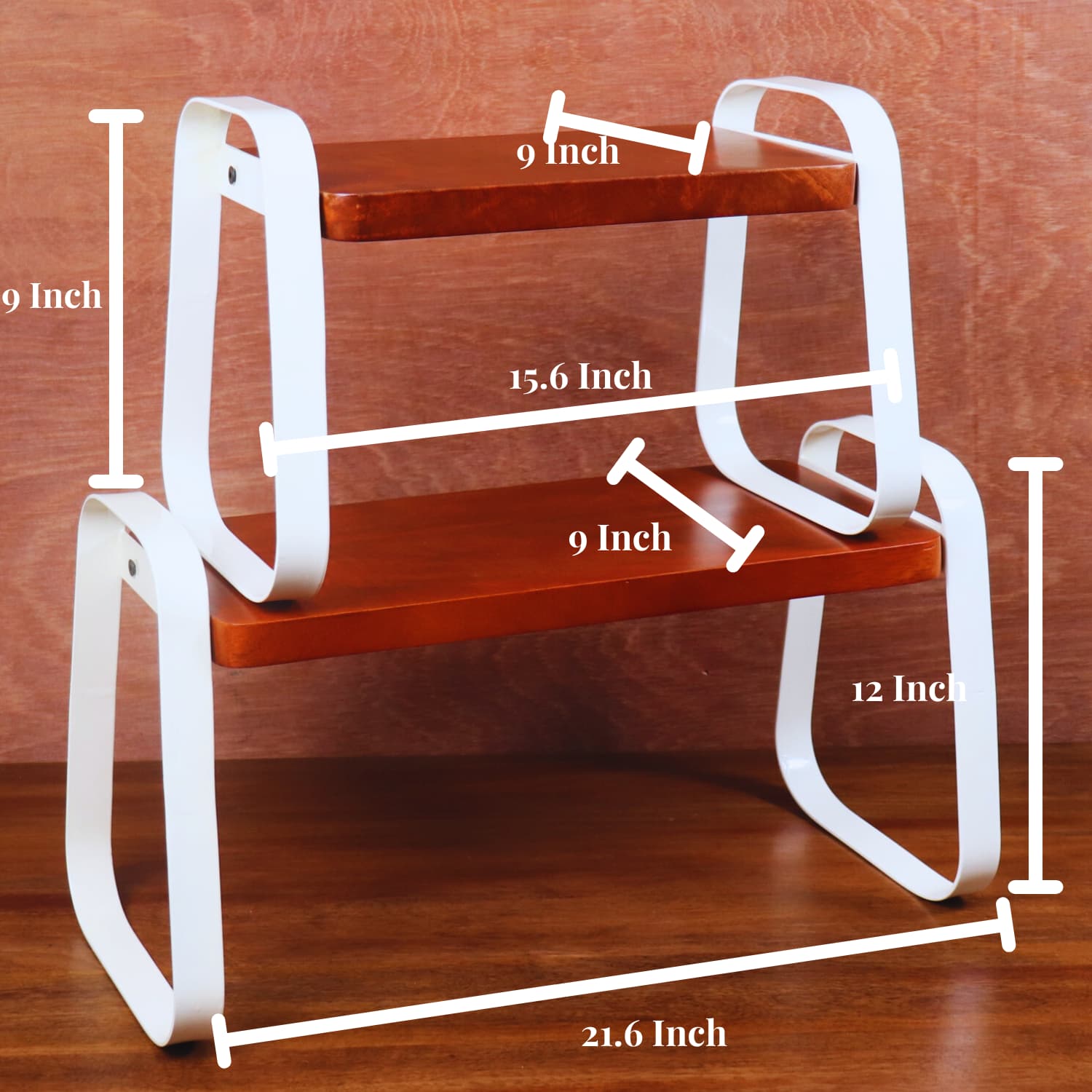 A wooden shelf unit with white metal supports is shown against a wooden background. The top shelf measures 9 inches wide by 6.6 inches deep, the middle shelf is 15.6 inches wide by 9 inches deep, and the bottom shelf stands at 12 inches high. Buy The Stackable Wooden Kitchen Organizer Set of 2 by LOOSEBUCKET online in India for optimal storage.